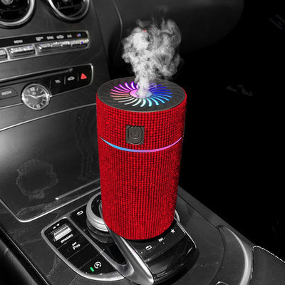 Red fabric car air purifier with colorful LED lights on car center console releasing fresh mist