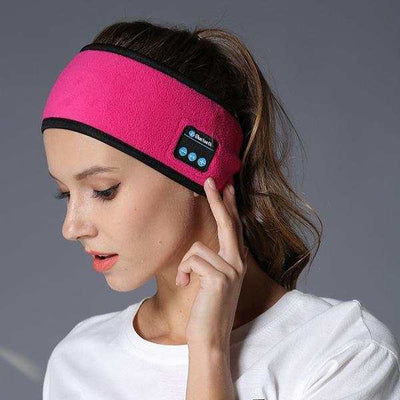 Woman wearing pink Bluetooth headband with built-in controls on side